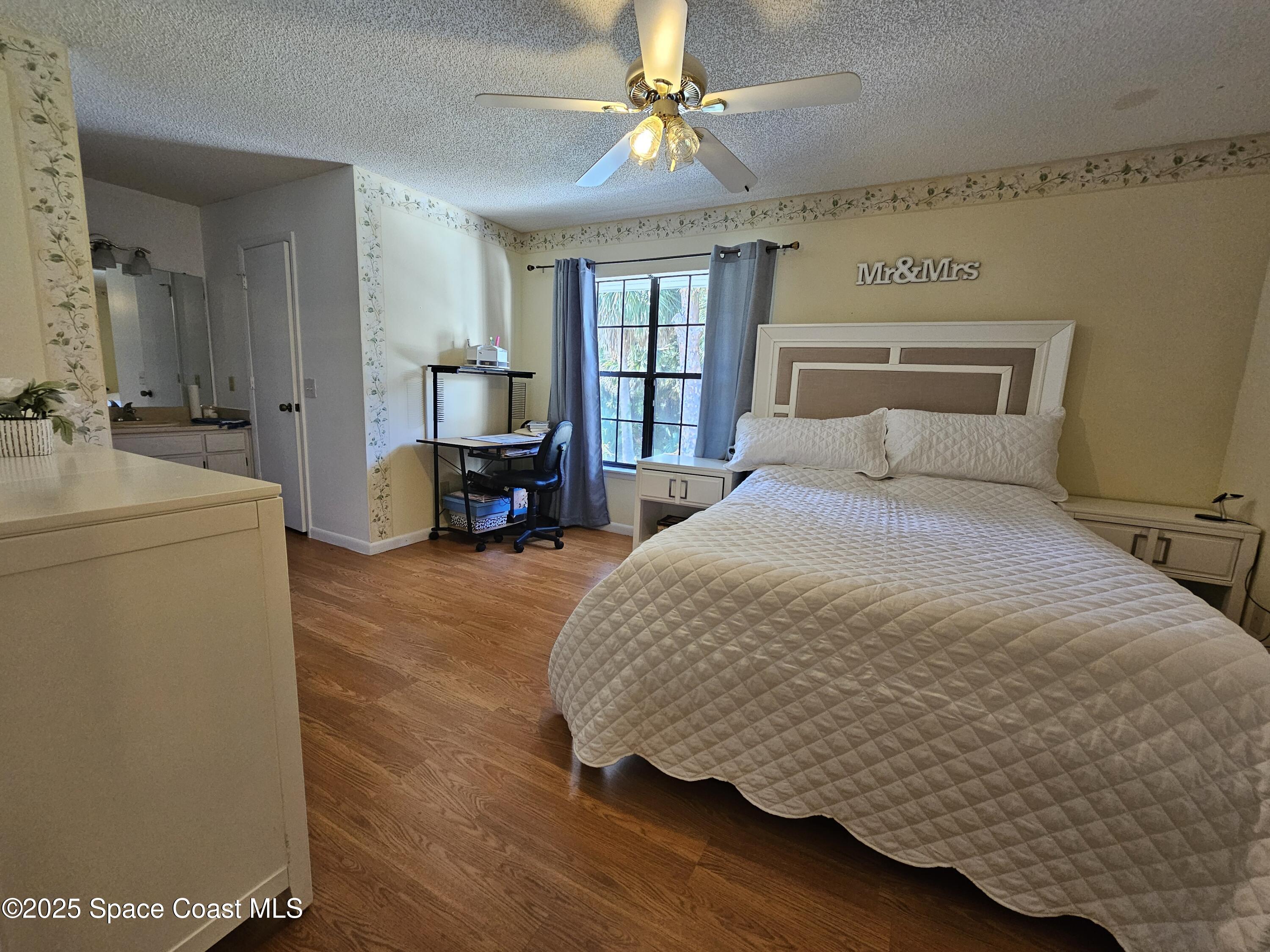 2314 Manor Drive Northeast Palm Bay, FL 32905 - Photo 16 of 23 a spacious bedroom with a bed and a chandelier