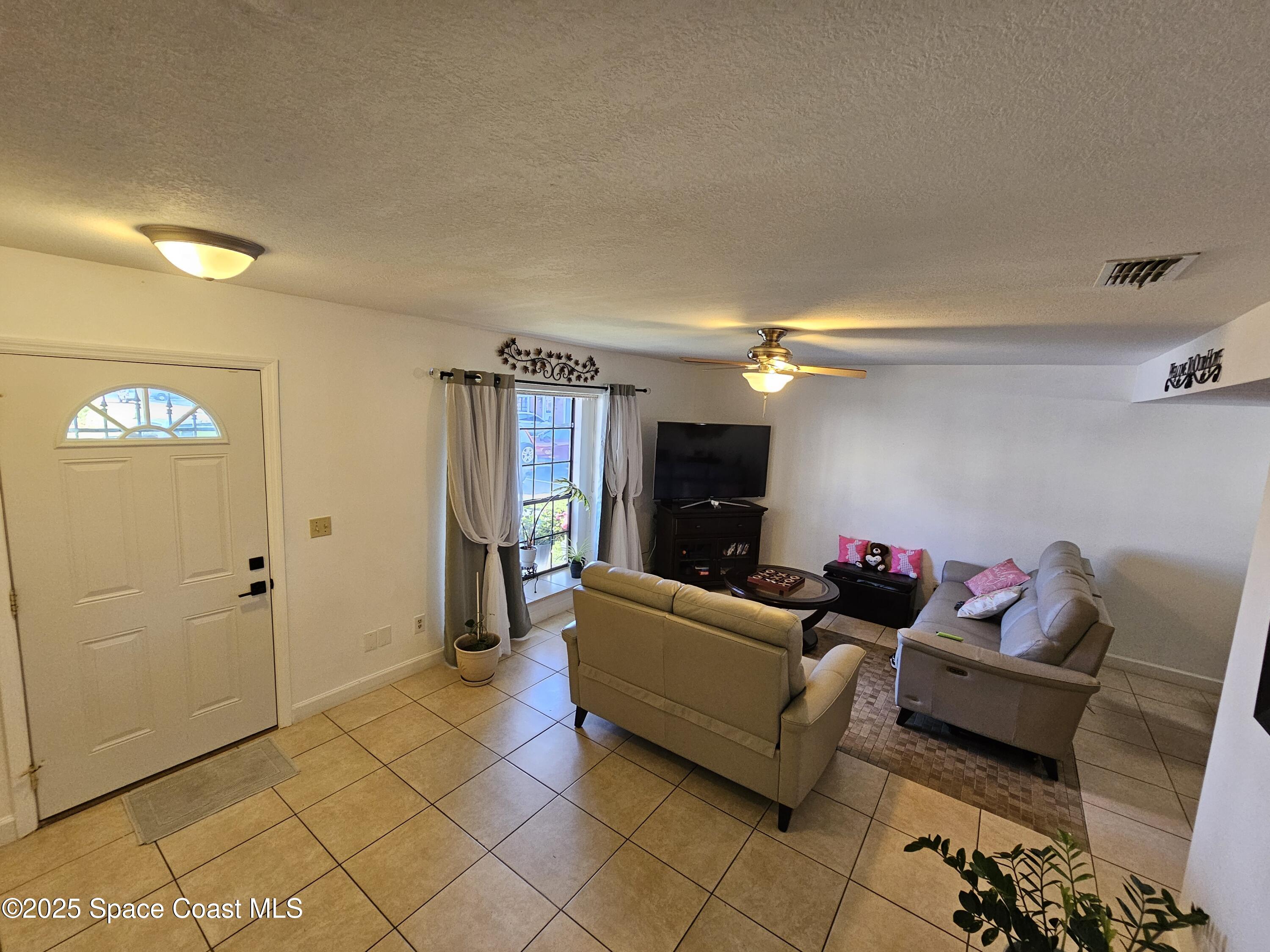 2314 Manor Drive Northeast Palm Bay, FL 32905 - Photo 2 of 23 a living room with furniture and a flat screen tv
