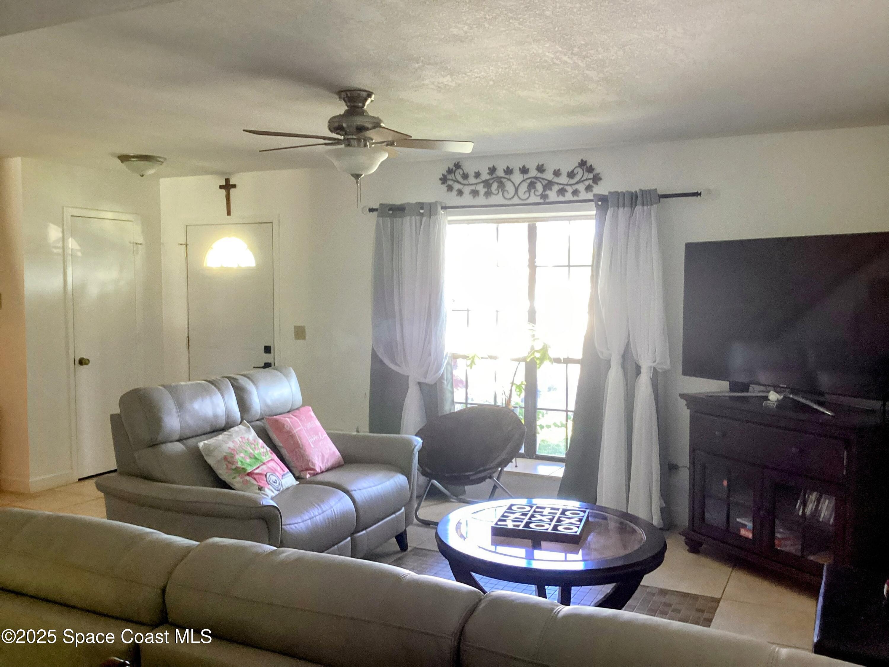 2314 Manor Drive Northeast Palm Bay, FL 32905 - Photo 3 of 23 a living room with furniture and a flat screen tv