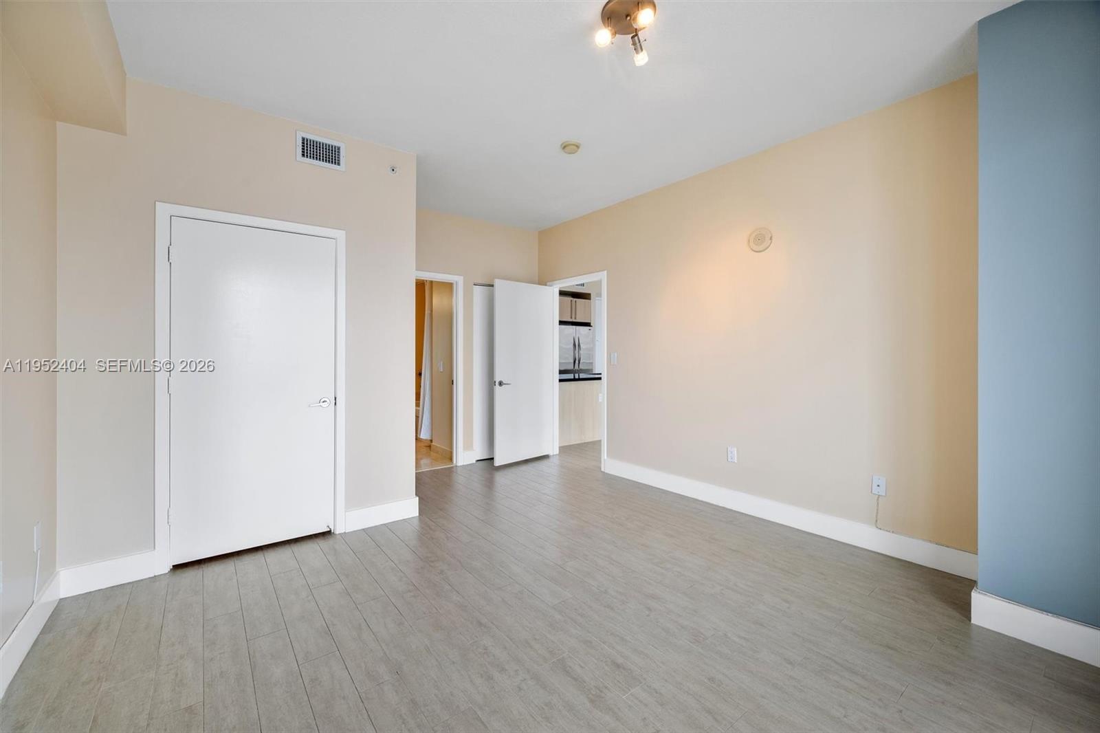 79 Southwest 12th Street, Unit 4004S Miami, FL 33130 - Photo 12 of 29 a view of an empty room with wooden floor and a window