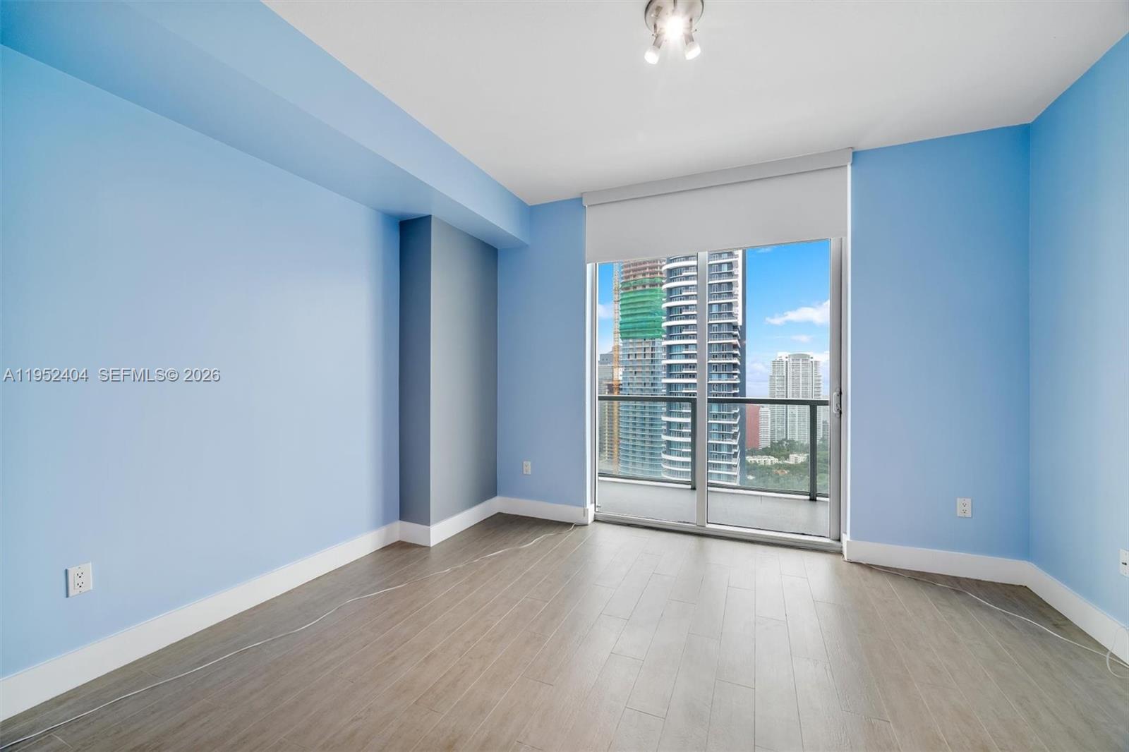 79 Southwest 12th Street, Unit 4004S Miami, FL 33130 - Photo 18 of 29 an empty room with wooden floor and windows