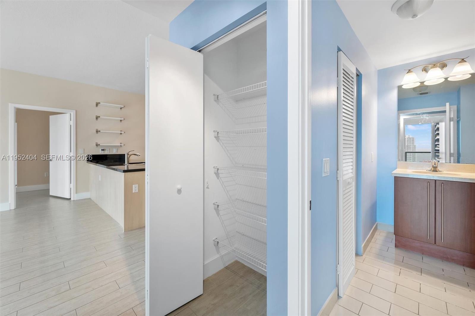 79 Southwest 12th Street, Unit 4004S Miami, FL 33130 - Photo 24 of 29 a view of a hallway with wooden floor a sink and a refrigerator