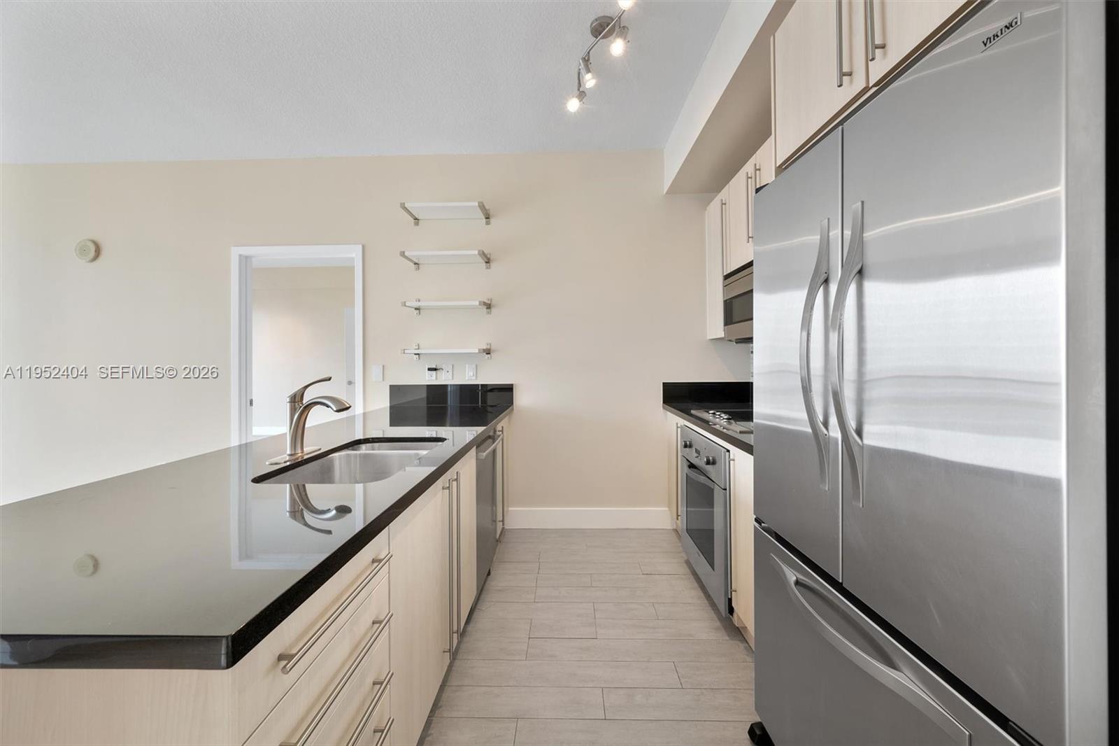 79 Southwest 12th Street, Unit 4004S Miami, FL 33130 - Photo 6 of 29 a kitchen with stainless steel appliances a sink and a refrigerator