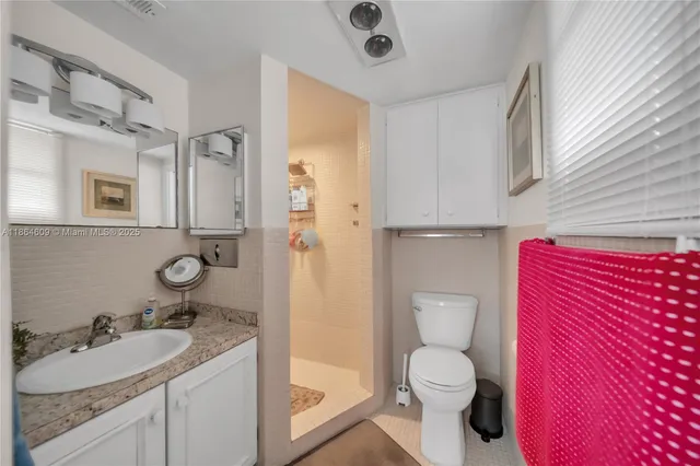 a bathroom with a granite countertop toilet sink and mirror