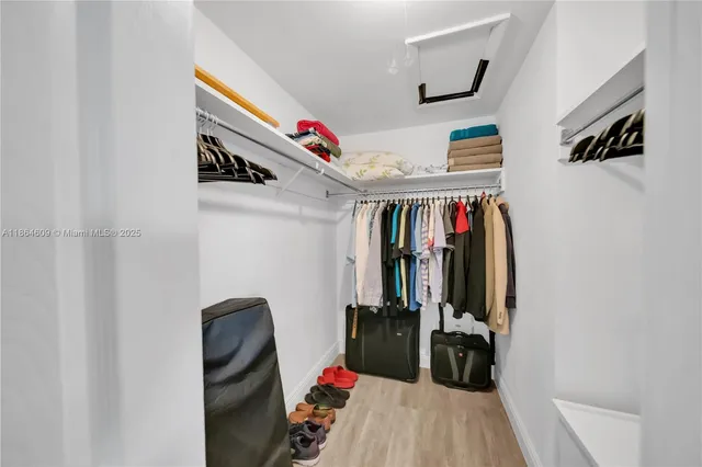 a view of walk in closet with clothes and shoes