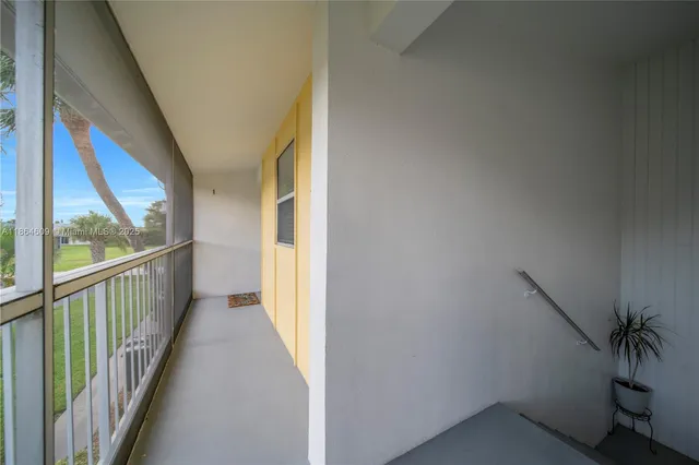 a view of a hallway with wooden floor and windows