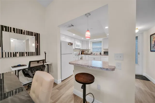 a kitchen with kitchen island a stove and a refrigerator