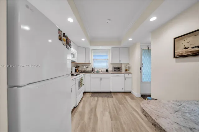 a kitchen with white cabinets and stainless steel appliances