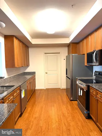 a kitchen with stainless steel appliances granite countertop a refrigerator a stove and a sink