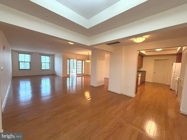 a view of empty room with wooden floor
