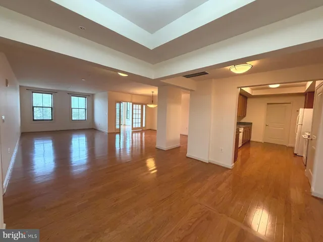 a view of empty room with wooden floor