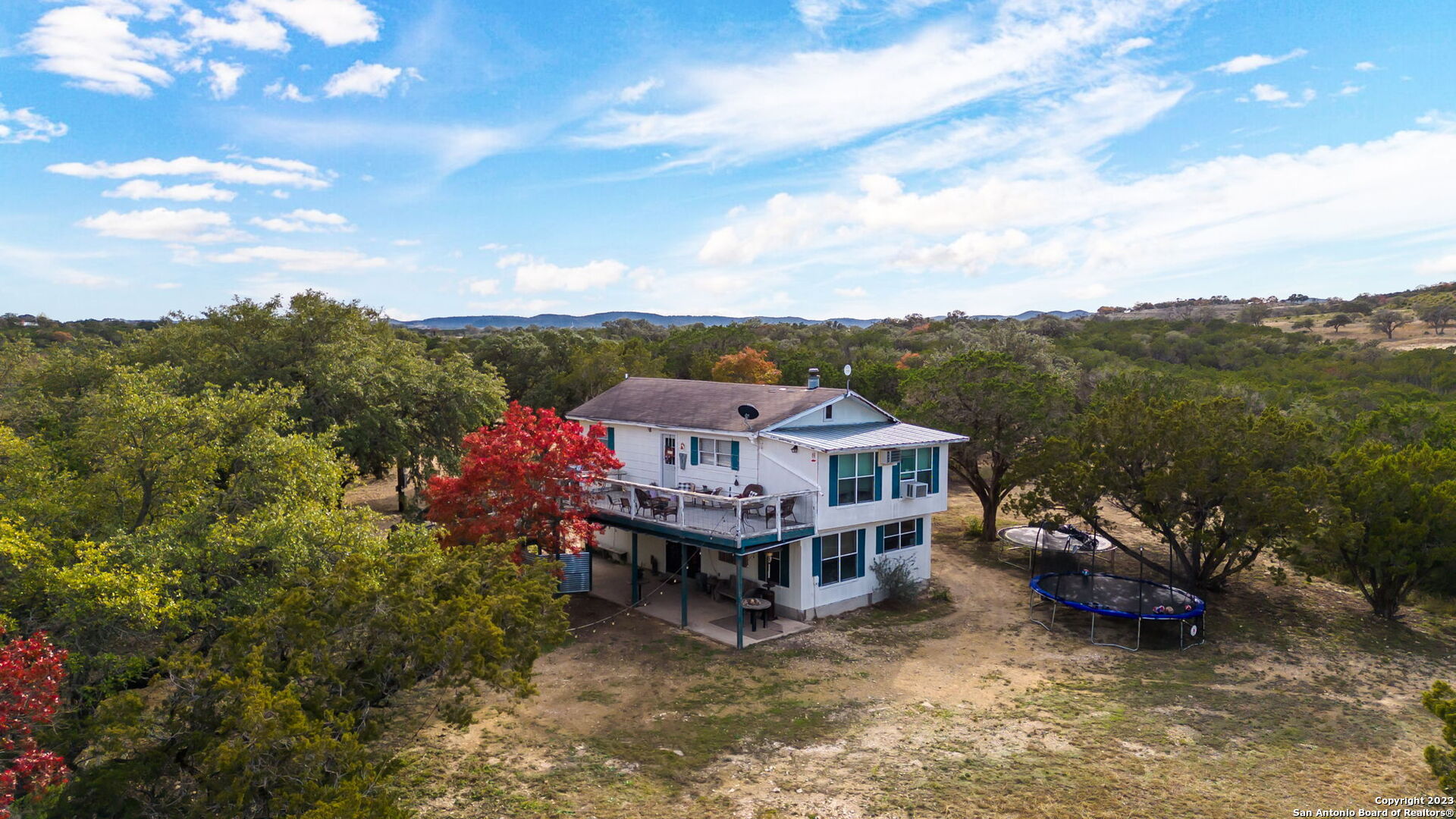 8417 Highway 16 Bandera, TX 78003 - Photo 2 of 28 a view of a house with a big yard and large trees