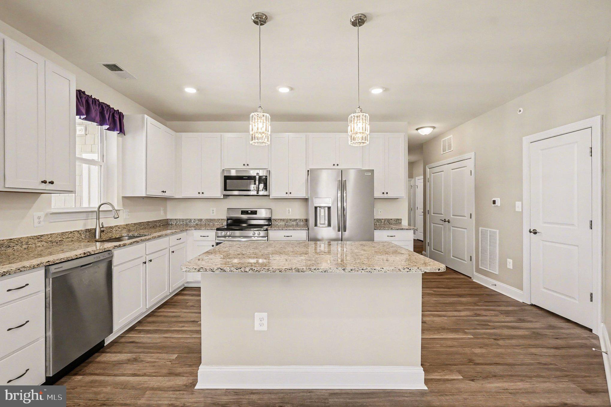 406 Bold Ruler Court, Unit 402 Havre de Grace, MD 21078 - Photo 12 of 59 a large kitchen with kitchen island a stove a sink a center island and wooden floor