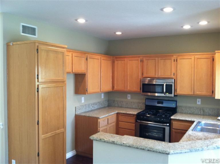 4249 Rusticview Court Moorpark, CA 93021 - Photo 2 of 7 a kitchen with granite countertop a refrigerator stove and microwave