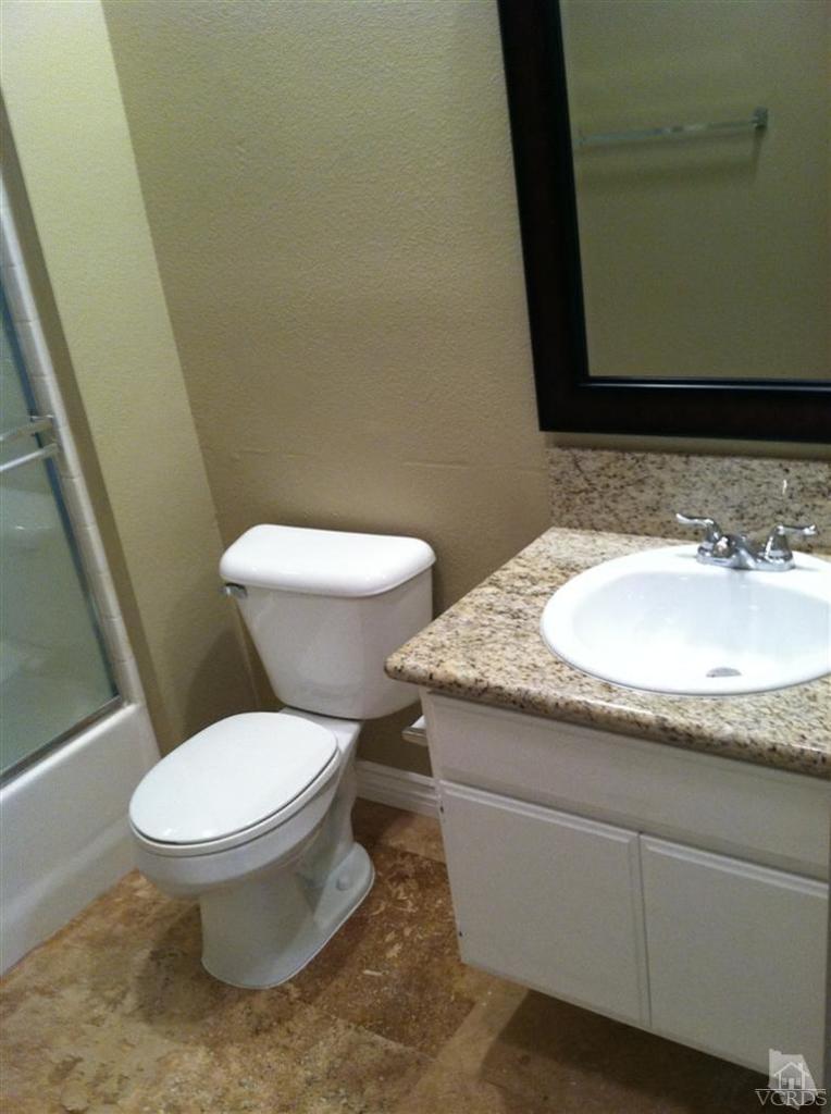 4249 Rusticview Court Moorpark, CA 93021 - Photo 7 of 7 a bathroom with a granite countertop toilet and a sink