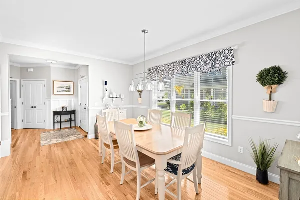 a kitchen with stainless steel appliances granite countertop a stove top oven a sink dishwasher a dining table and chairs with wooden floor