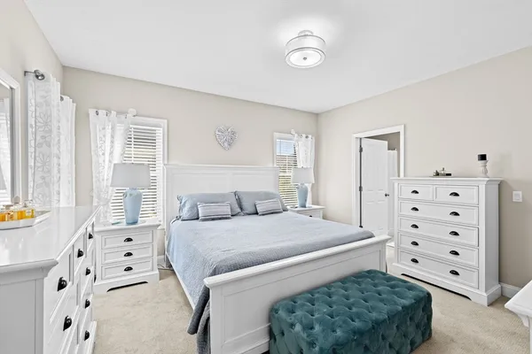 a bedroom with a bed a dresser and a window