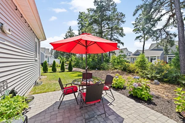 a view of a patio with a table and chairs under an umbrella