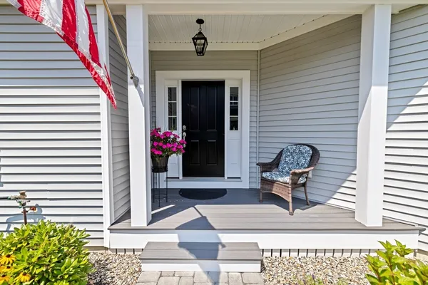 a view of house with entryway and flowers