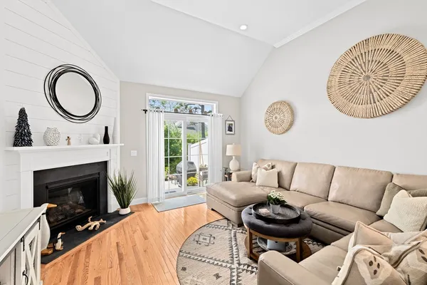 a living room with furniture a fireplace and a large window