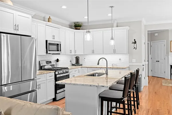 a kitchen with stainless steel appliances granite countertop a sink stove and refrigerator