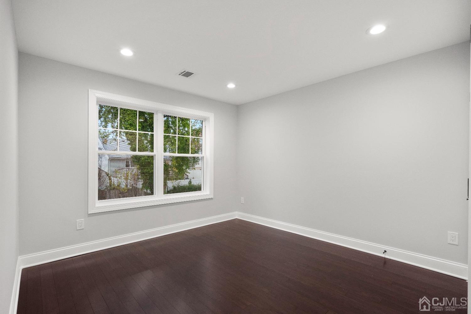 42 Wayne Street Edison, NJ 08817 - Photo 13 of 22 an empty room with wooden floor and windows