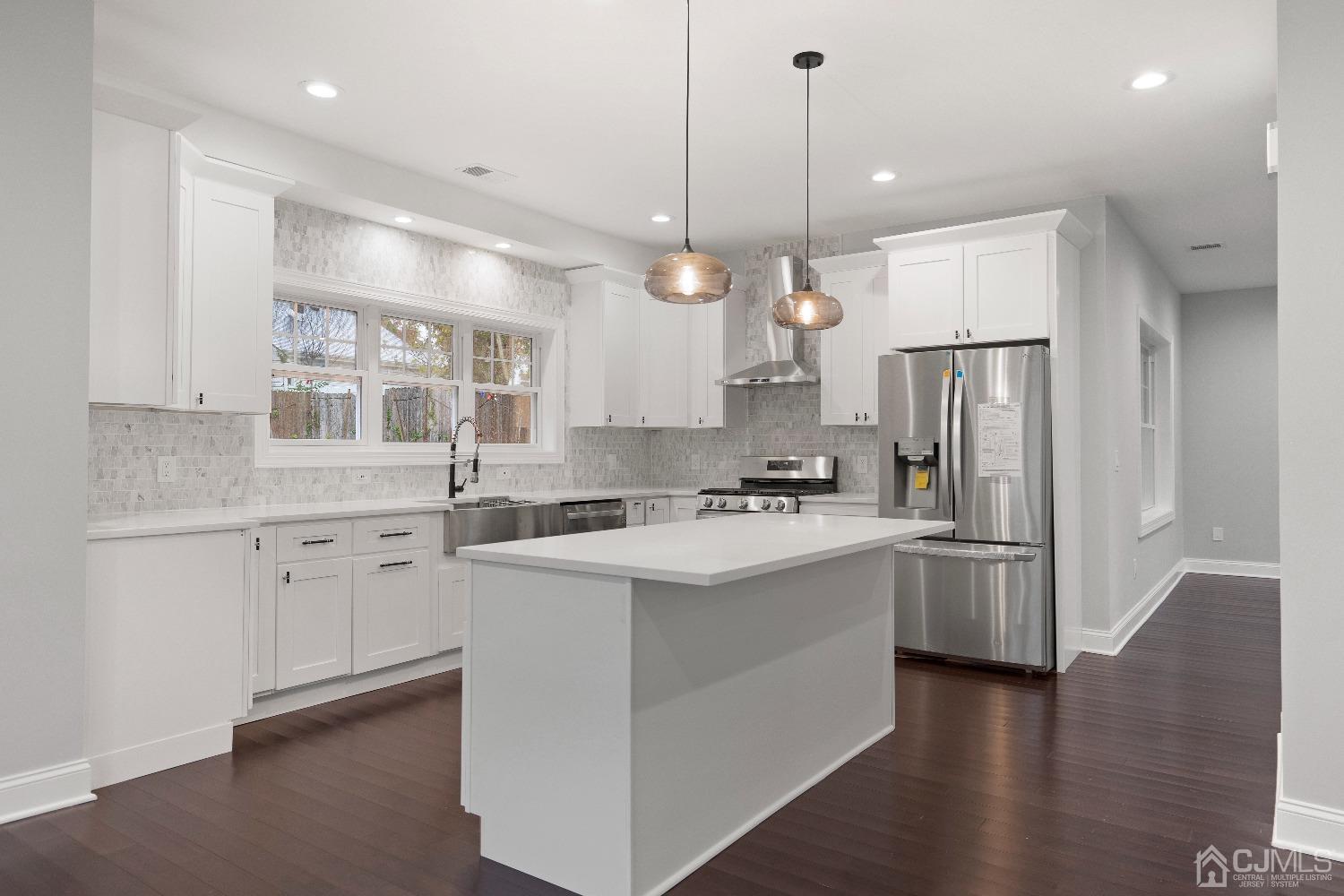 42 Wayne Street Edison, NJ 08817 - Photo 6 of 22 a kitchen with white cabinets and stainless steel appliances