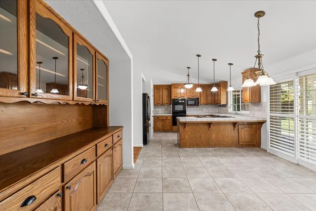 a kitchen with stainless steel appliances granite countertop a stove a sink and a wooden floors