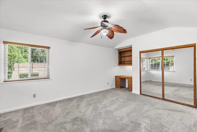 a view of an empty room with cabinet and a chandelier fan