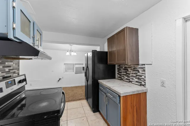 a kitchen with granite countertop a stove and refrigerator