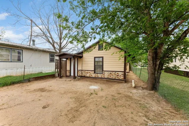 a view of a house with a yard and tree