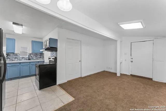 a kitchen with a refrigerator and a stove top oven