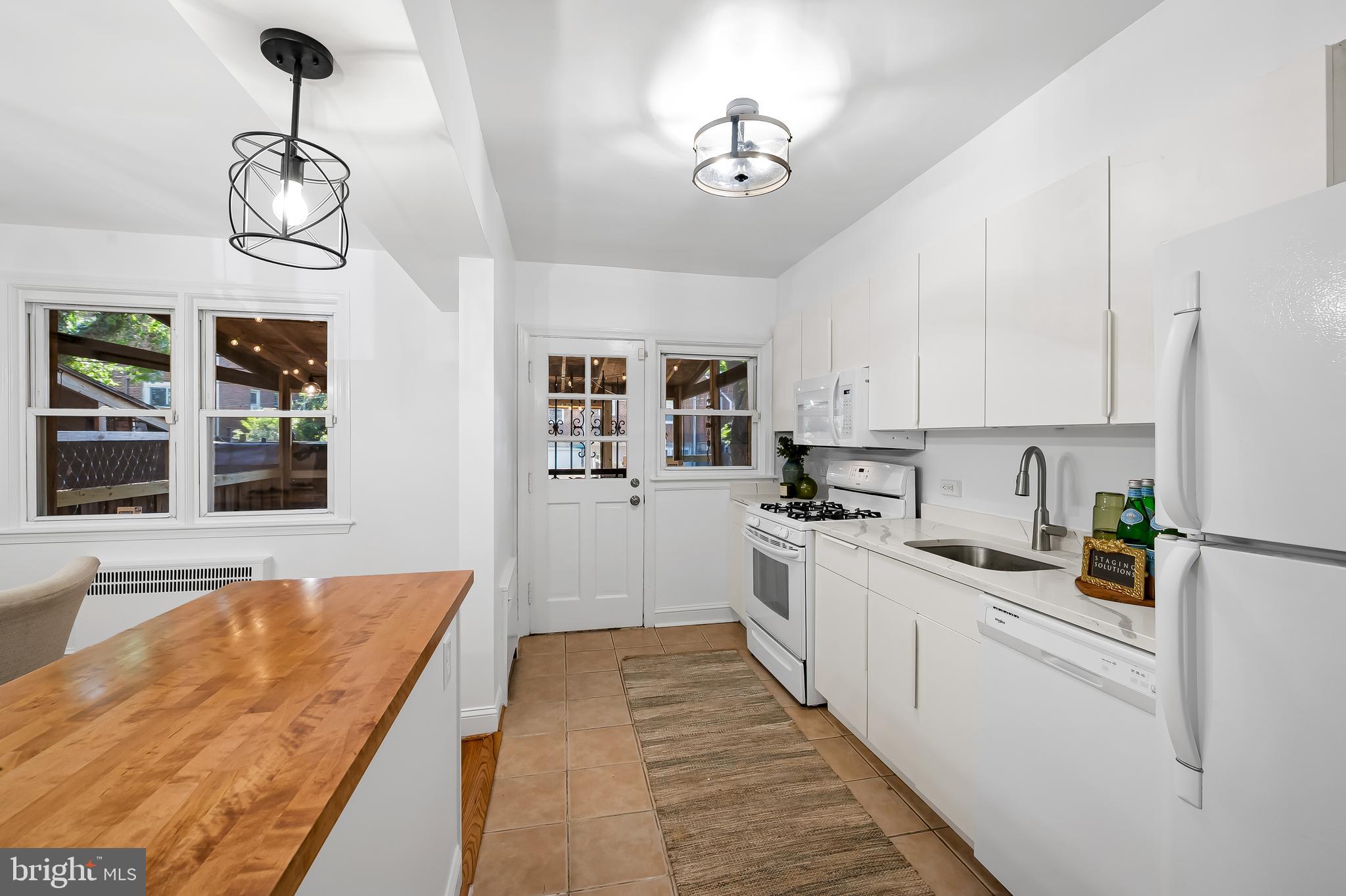 3718 Yolando Road Baltimore, MD 21218 - Photo 23 of 53 a kitchen with stainless steel appliances granite countertop a stove top oven a sink a refrigerator white cabinets and wooden floor