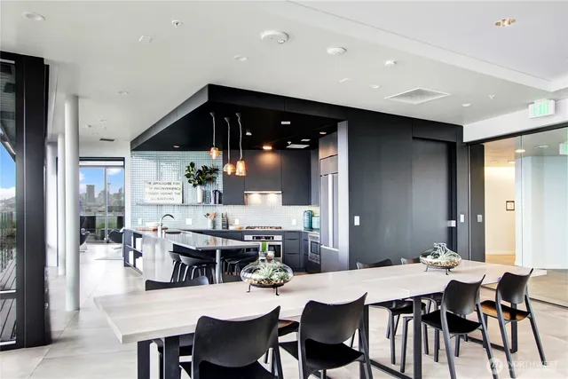 a dining hall with stainless steel appliances a table and chairs