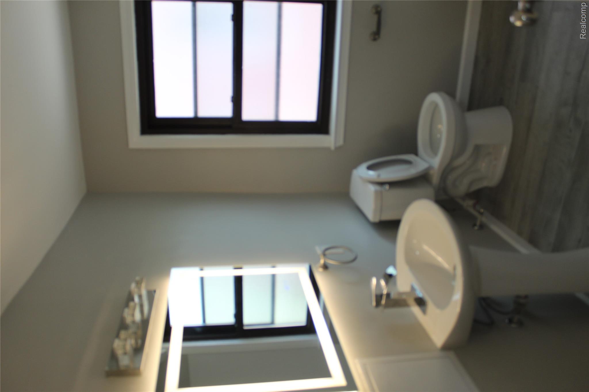 5543 Balfour Road Detroit, MI 48224 - Photo 11 of 54 Bathroom featuring a white pedestal sink, toilet, and wood-finish flooring