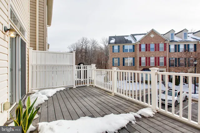 a view of a brick house with wooden floor and fence