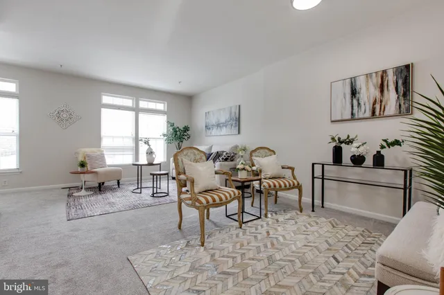a living room with furniture a rug and white walls