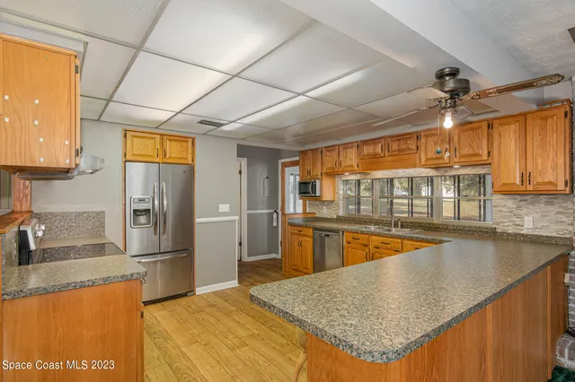 a kitchen with stainless steel appliances granite countertop a sink a stove and a refrigerator