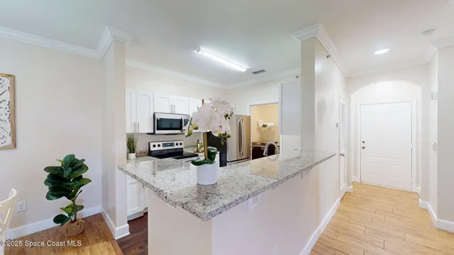 a kitchen with granite countertop a sink a counter top space and cabinets