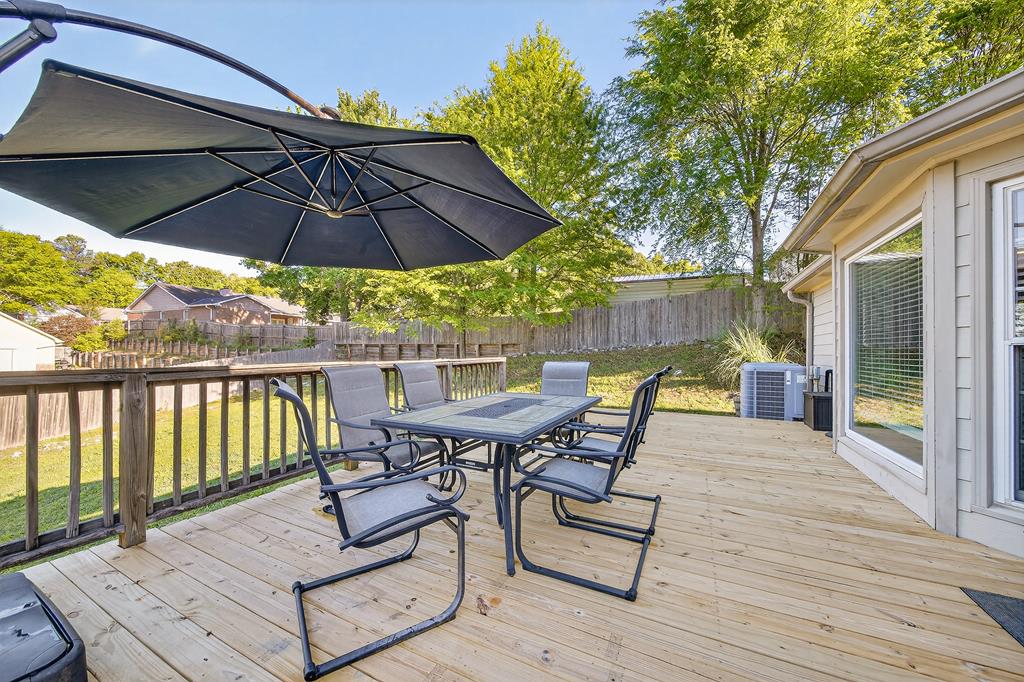 7333 Cedar Creek Loop Columbus, GA 31904 - Photo 37 of 37 a view of a roof deck with table and chairs under an umbrella with wooden floor