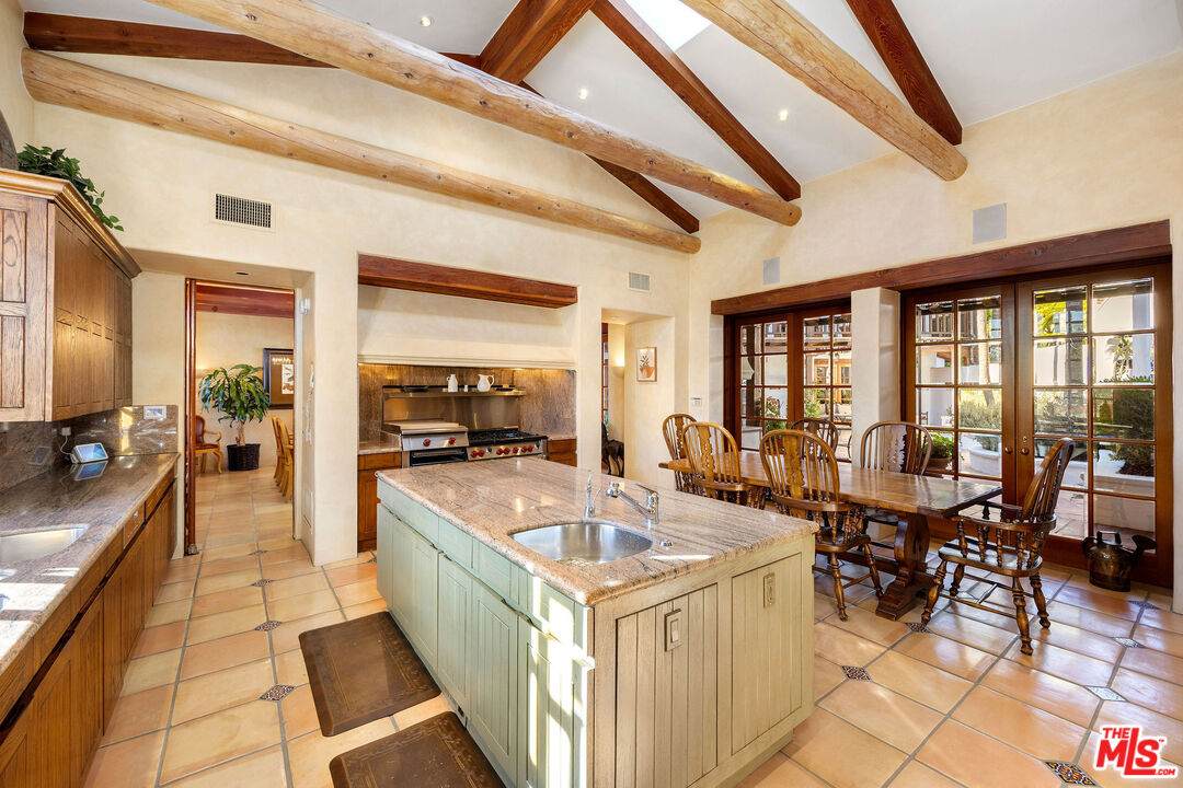 25127 Jim Bridger Road Hidden Hills, CA 91302 - Photo 15 of 50 a dining hall with couches a flat screen tv and couches with wooden floor
