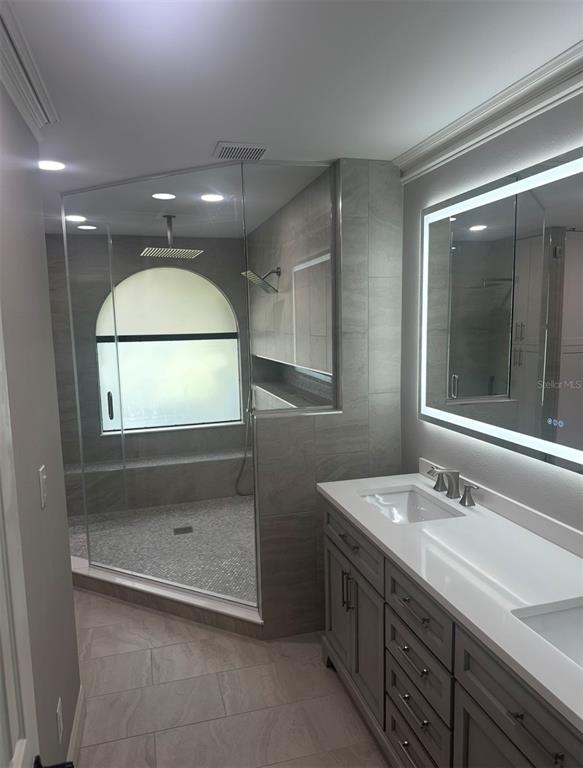 18306 Pleasant Ridge Place Lutz, FL 33548 - Photo 4 of 8 a bathroom with a sink a shower and a mirror