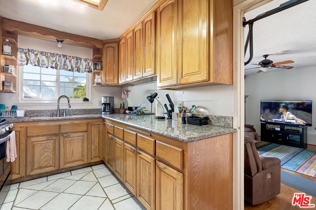 1657 East 218th Street Carson, CA 90745 - Photo 14 of 24 a kitchen with stainless steel appliances granite countertop a sink dishwasher stove and cabinets