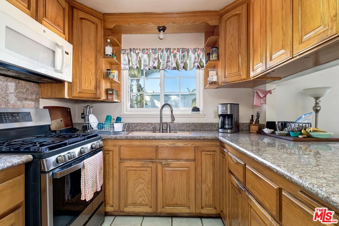 1657 East 218th Street Carson, CA 90745 - Photo 15 of 24 a kitchen with stainless steel appliances granite countertop a sink stove and cabinets