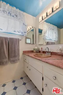 a bathroom with a granite countertop sink mirror and toilet