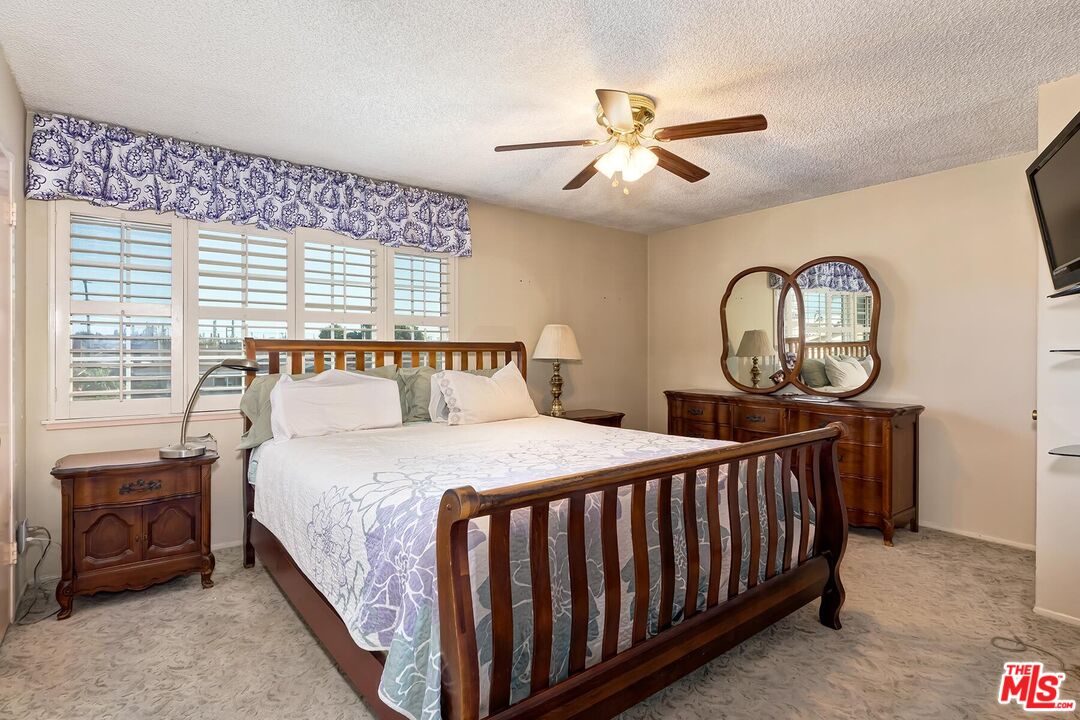 1657 East 218th Street Carson, CA 90745 - Photo 19 of 24 a bedroom with a bed a chandelier and dresser