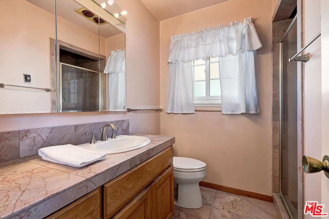 1657 East 218th Street Carson, CA 90745 - Photo 20 of 24 a bathroom with a granite countertop sink toilet and mirror