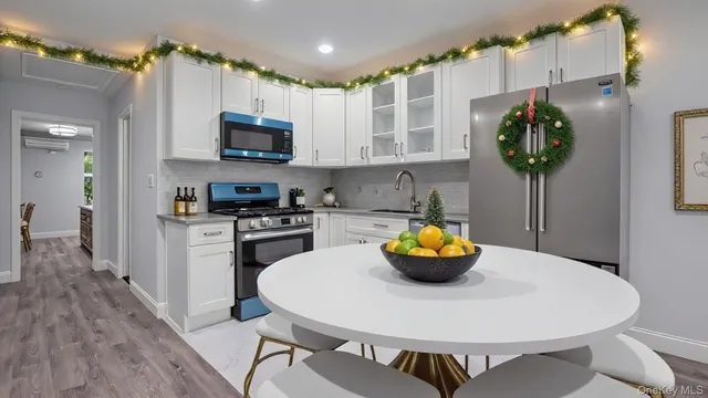 a kitchen with stainless steel appliances a table chairs and microwave