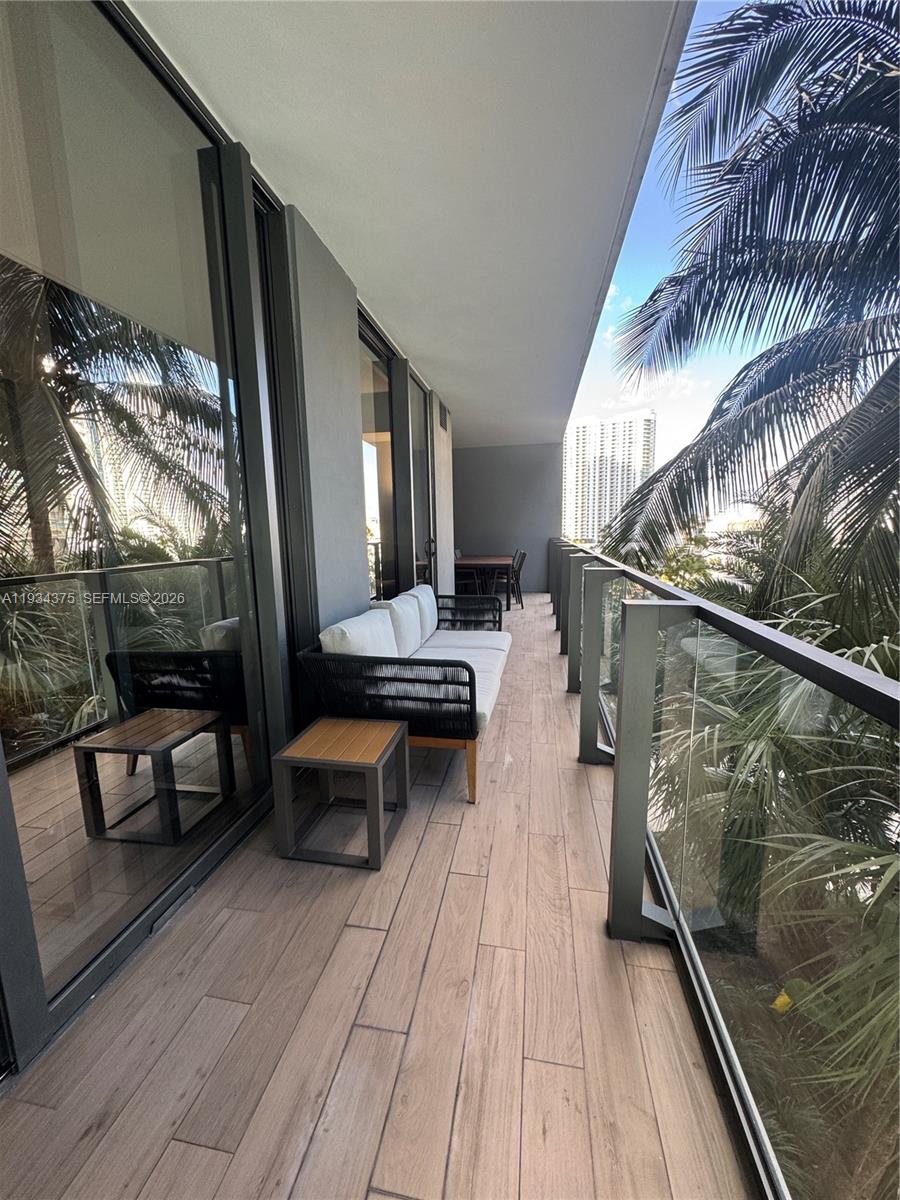 88 Southwest 7th Street, Unit 805 Miami, FL 33130 - Photo 2 of 14 a balcony with chairs and wooden floor