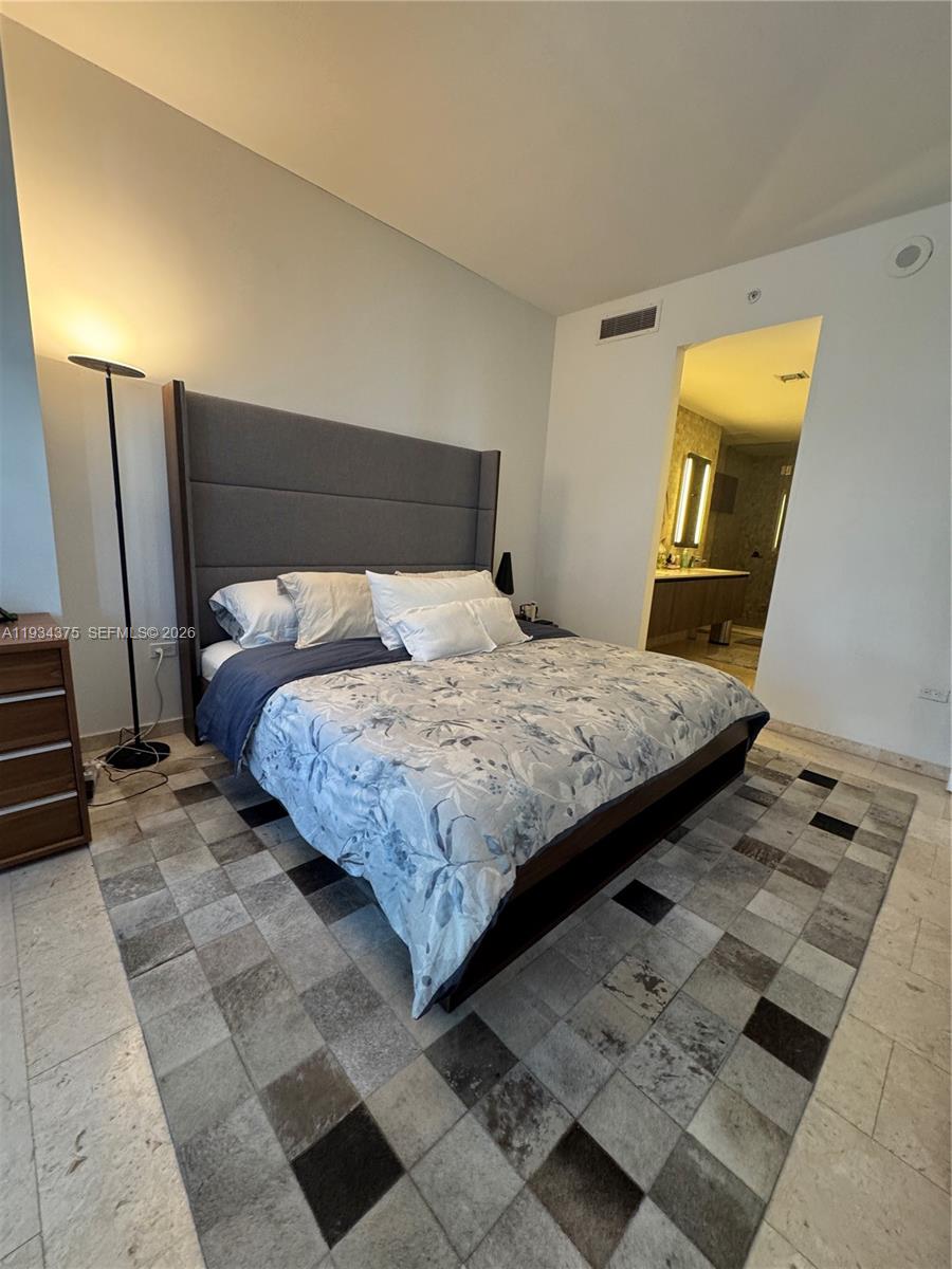 88 Southwest 7th Street, Unit 805 Miami, FL 33130 - Photo 6 of 14 a bedroom with a bed and a mirror on the dresser